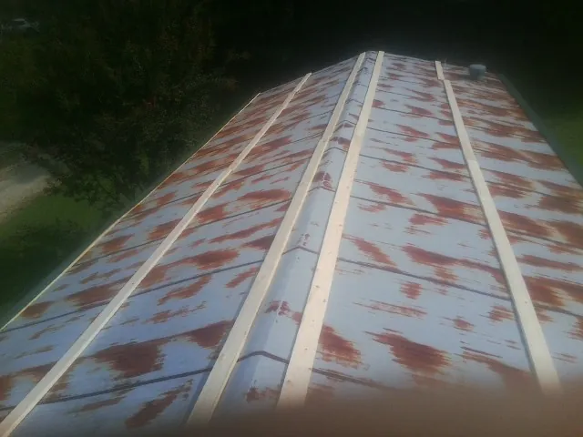 Rusted metal roof panels with new wood purlins before replacement — Storm Damage Roof Repair in Intercession City by Roofing Brothers